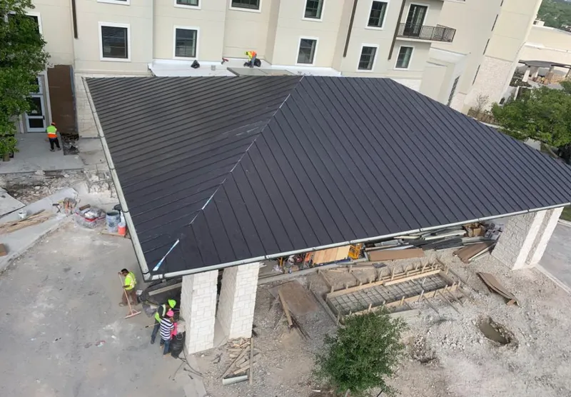 Metal roofing installation team working on a commercial building in Monument